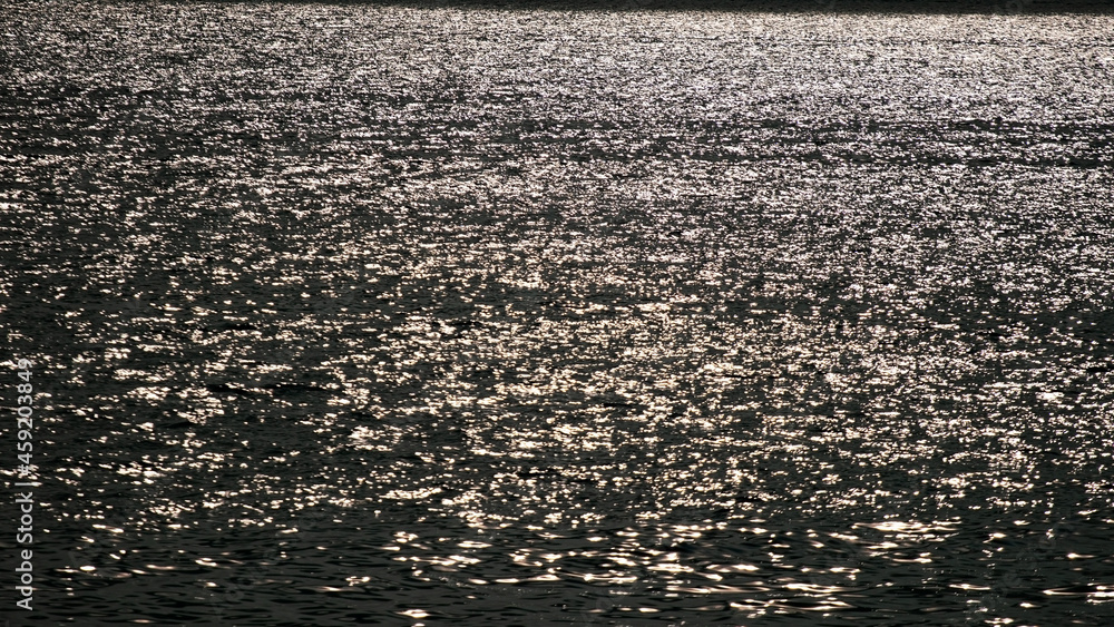 鸟瞰深色海面的纹理，海面上有小波浪，美丽的日落或日落