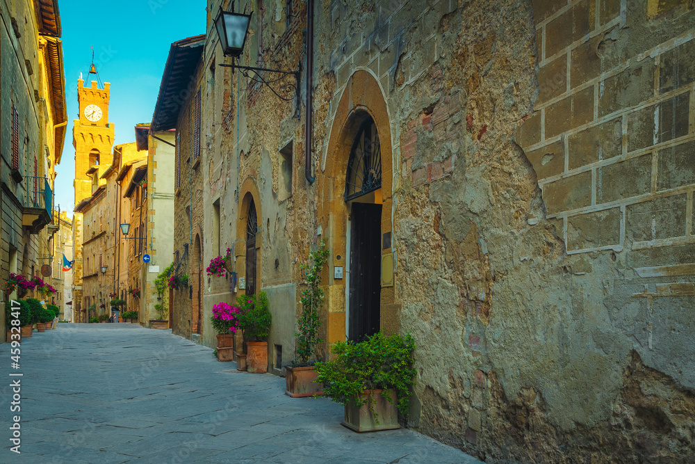 Paved street and entrances decorated with colorful flowers, Pienza, Italy