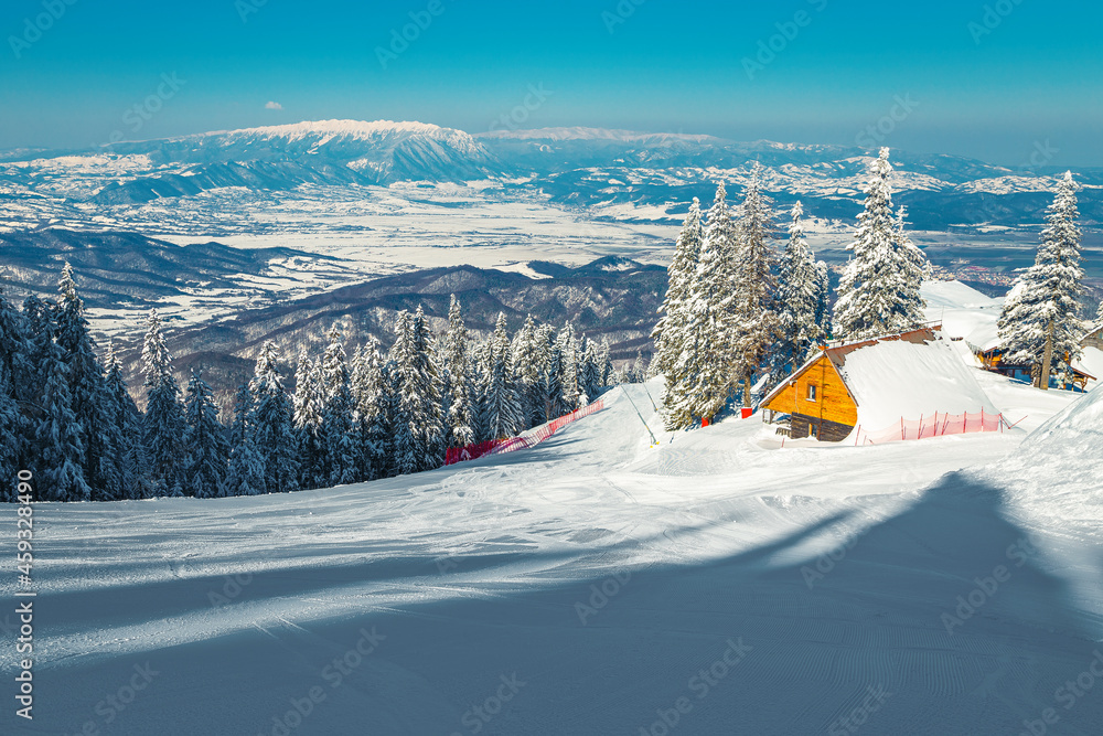 罗马尼亚喀尔巴阡山山坡上的白雪覆盖的小木屋