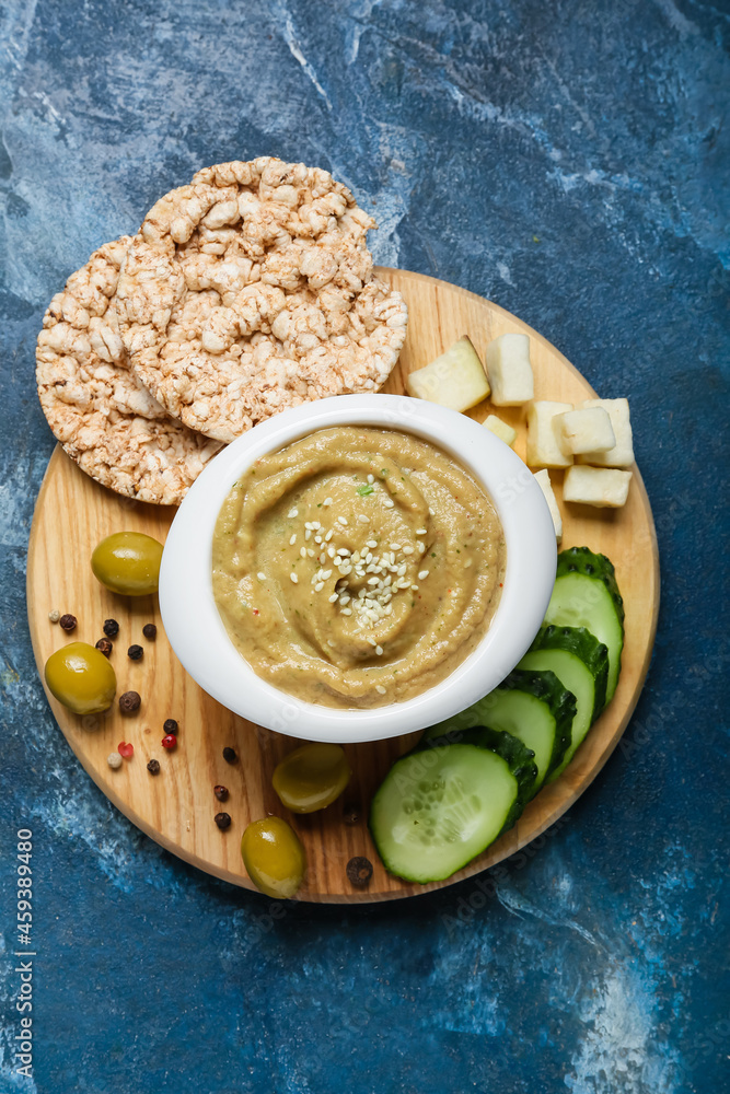 碗里有美味的baba ghanoush、米饼干和彩色背景蔬菜