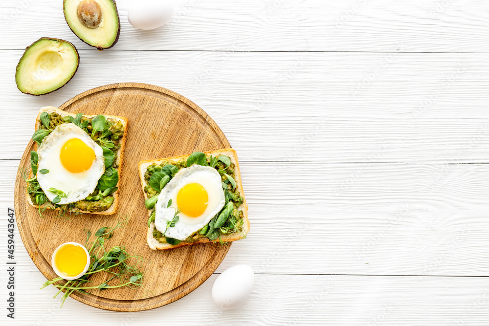 Open sandwich with avocado spinach cream and eggs. Top view