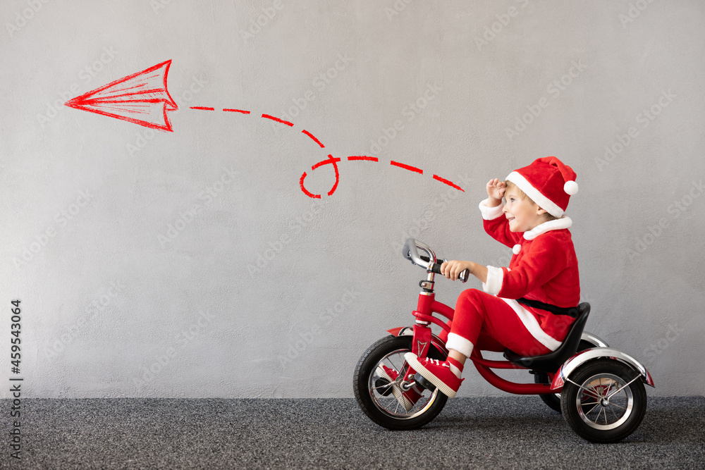 Happy child riding bike. Christmas holiday concept