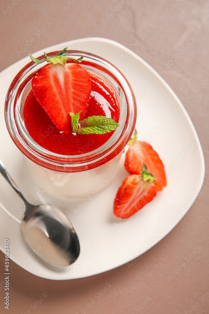 美味的panna cotta，配草莓和薄荷，玻璃色背景，特写