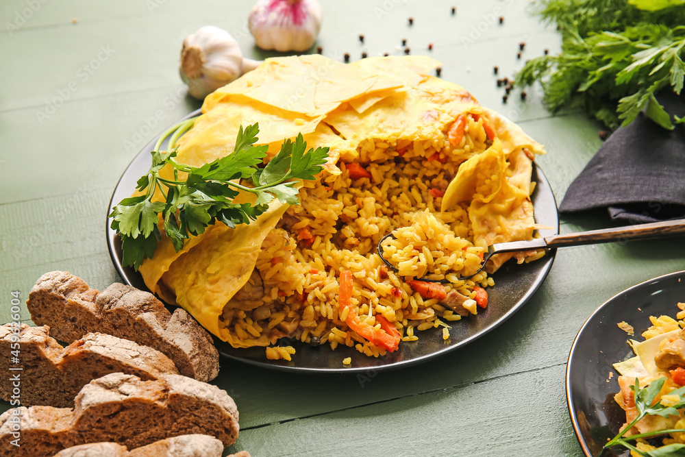 Plate with tasty Shah Pilaf on color wooden background