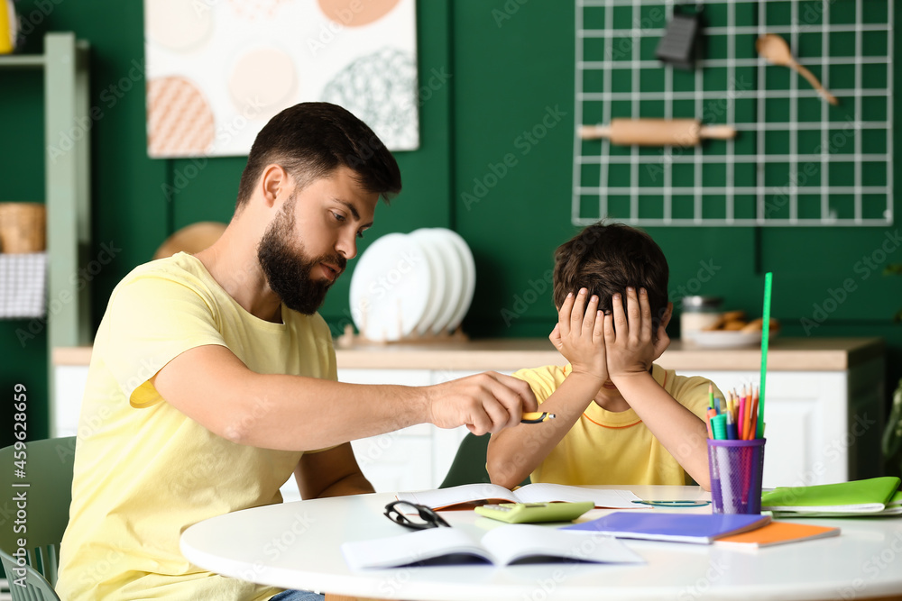 疲惫的小男孩和他的父亲在家上课