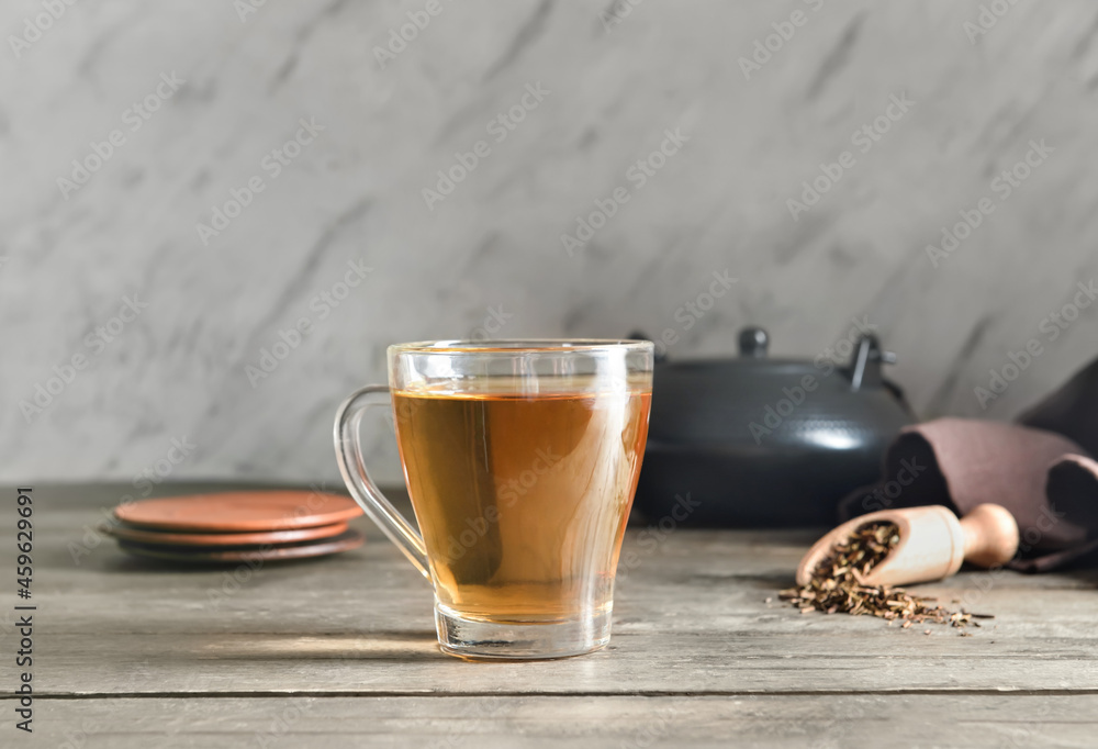 Cup of tasty hojicha green tea on table