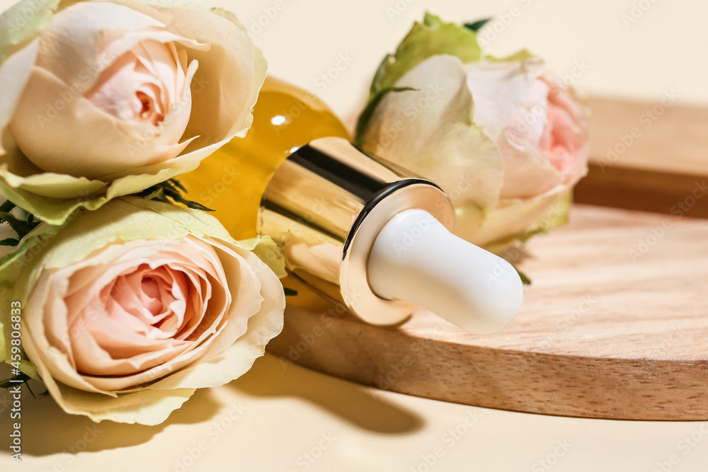 Bottle of healthy essential oil with flowers on light background, closeup