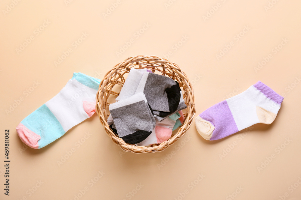 Basket with different socks on color background