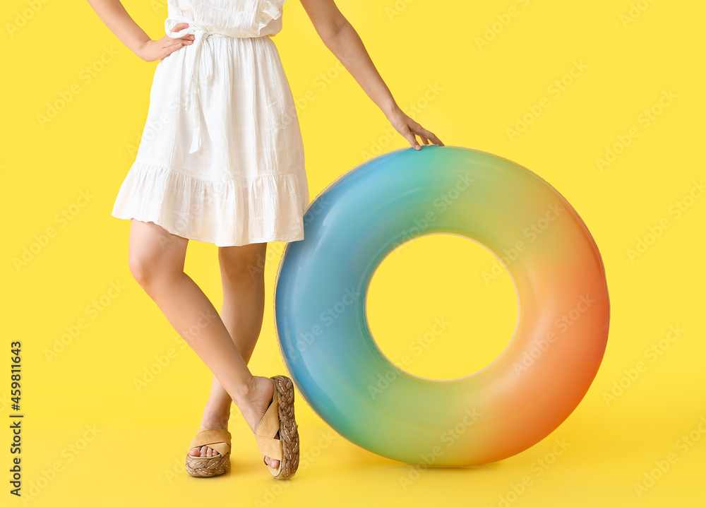 Young woman with inflatable ring on color background