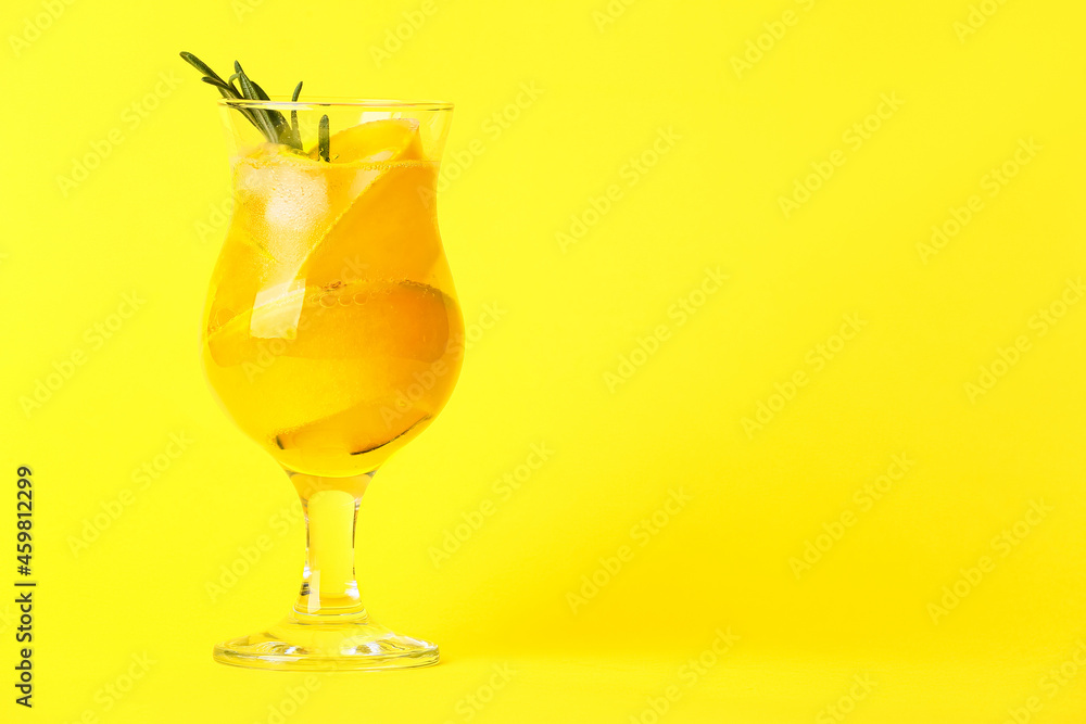 Glass of cold melon cocktail on yellow background