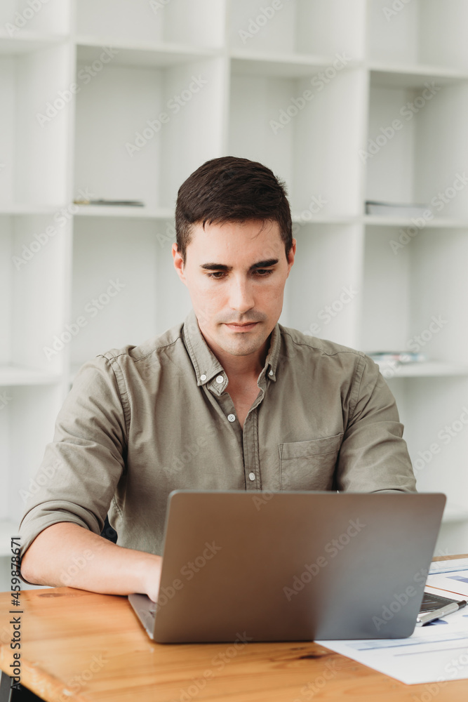 Businessman in shirt working on his laptop in an office. Open space office