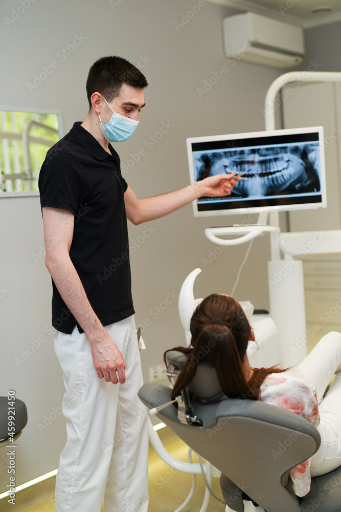 Patient having dental checkup with monitor. Professional dental specialist working with patient teet