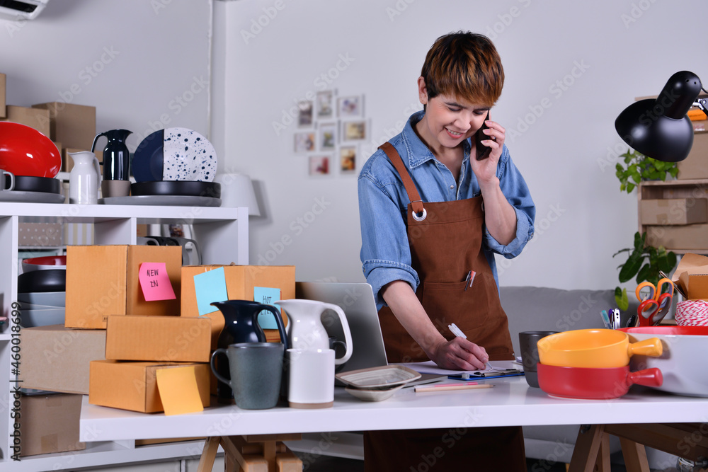 Mature Asian woman entrepreneur, Business owner using smartphone checking address and delivery detai