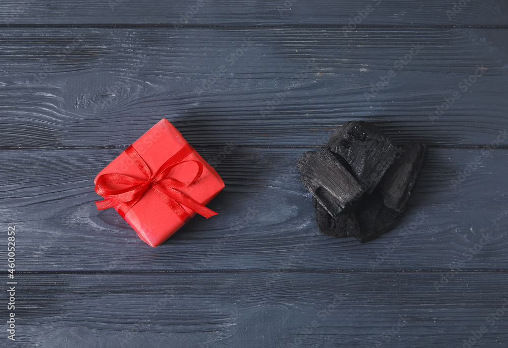 Coal and gift on dark wooden background