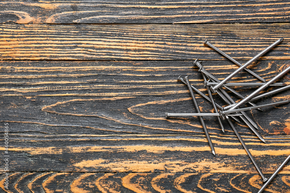 Pile of nails for furniture assembling on wooden background