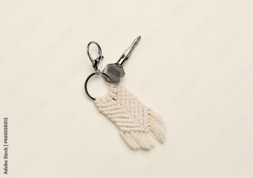 Key with handmade cotton keychain on light background