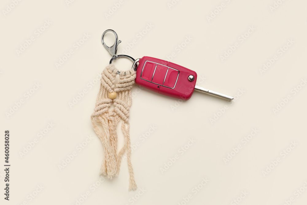 Car key with handmade cotton keychain on light background