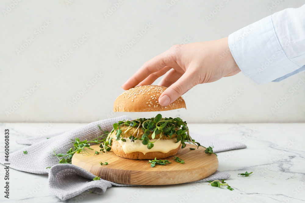 女人在餐桌上准备美味的素食汉堡