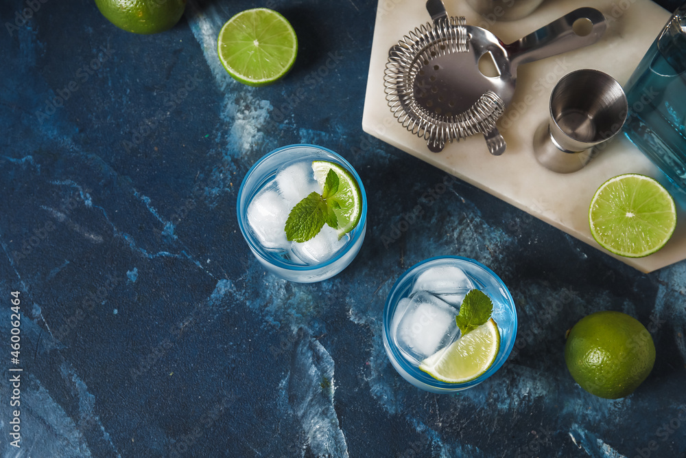 Glasses of cold gin tonic on color background