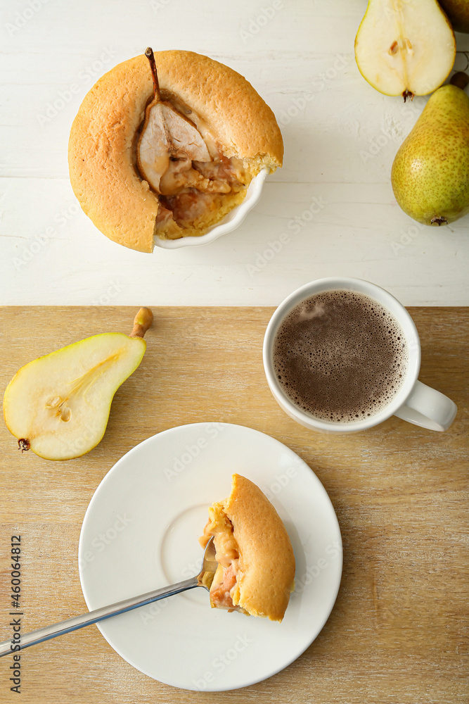 Tasty pear pot pie and cup of coffee on light wooden background