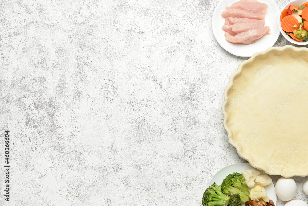 Raw dough and ingredients for preparing pot pie on white background