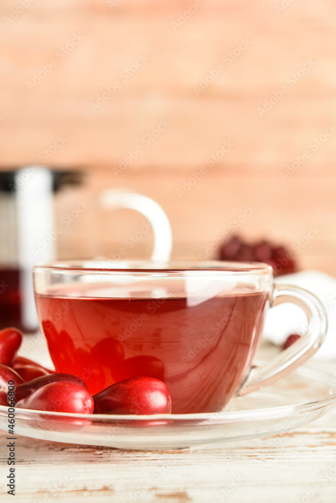 Glass cup of natural dogwood drink on light table, closeup