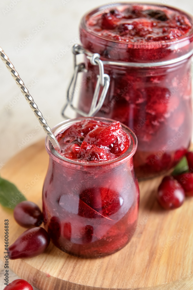 Jars with delicious dogwood jam on table, closeup