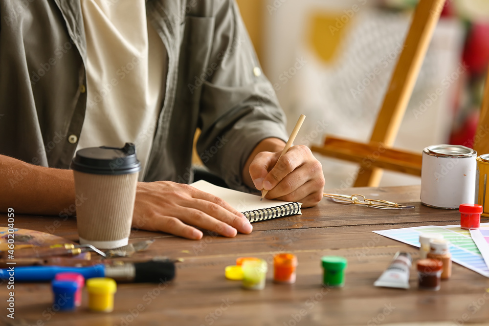 Young male artist drawing in workshop, closeup