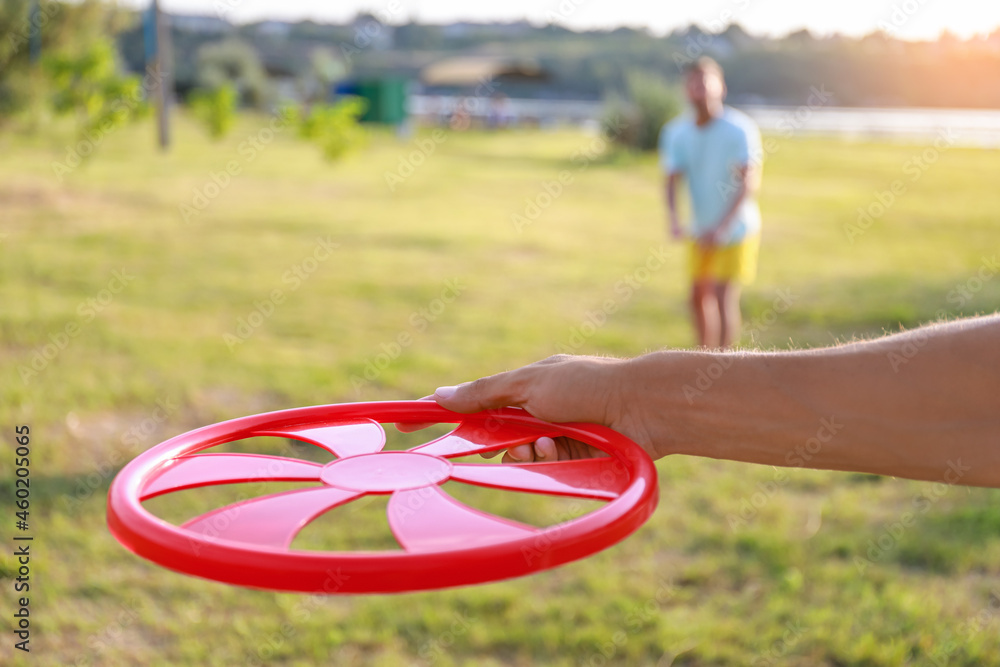 Young man playing frisbee in park, closeup