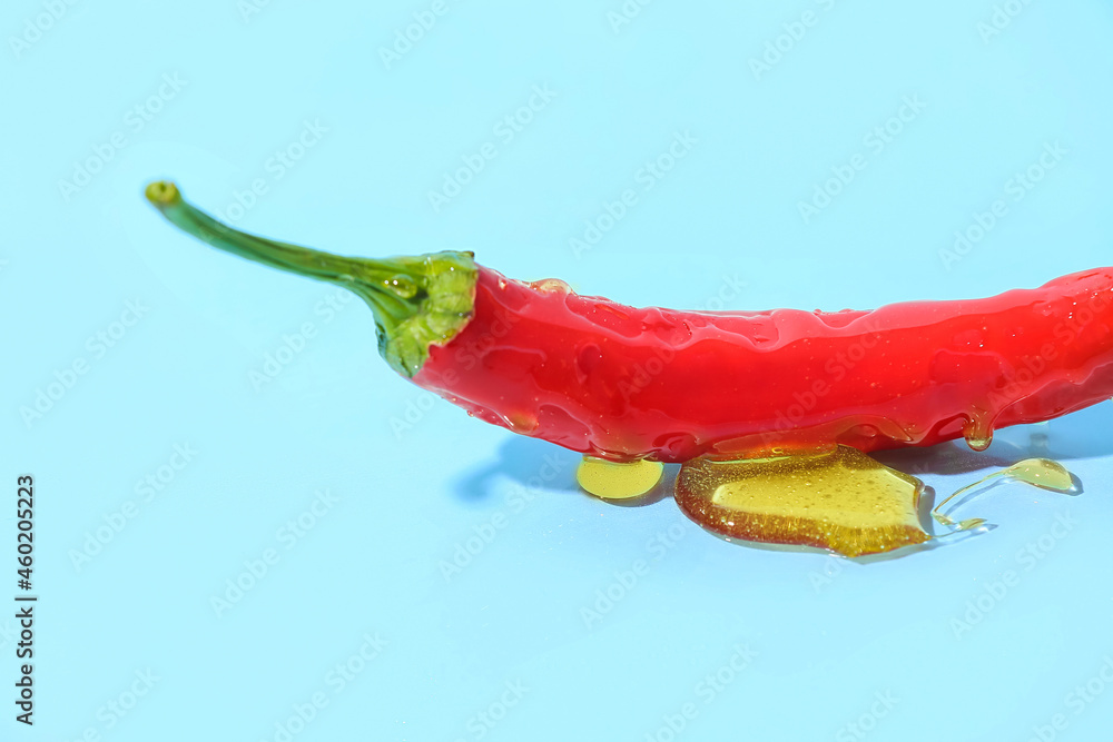 Red chili pepper with honey on color background, closeup