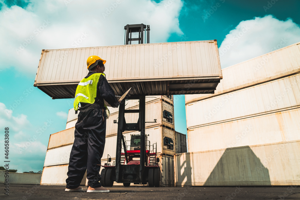 Young African American woman worker at overseas shipping container yard . Logistics supply chain man