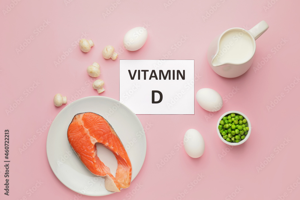 Text VITAMIN D and different healthy products on pink background