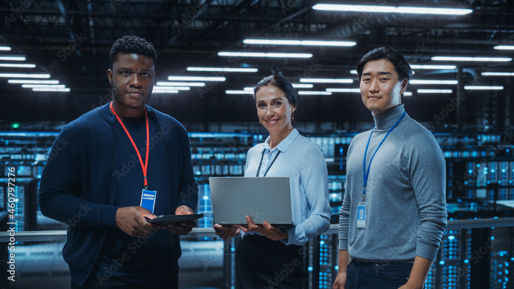 Diverse Team of Data Center System Administrators and IT Specialists Use Laptop and Tablet Computers