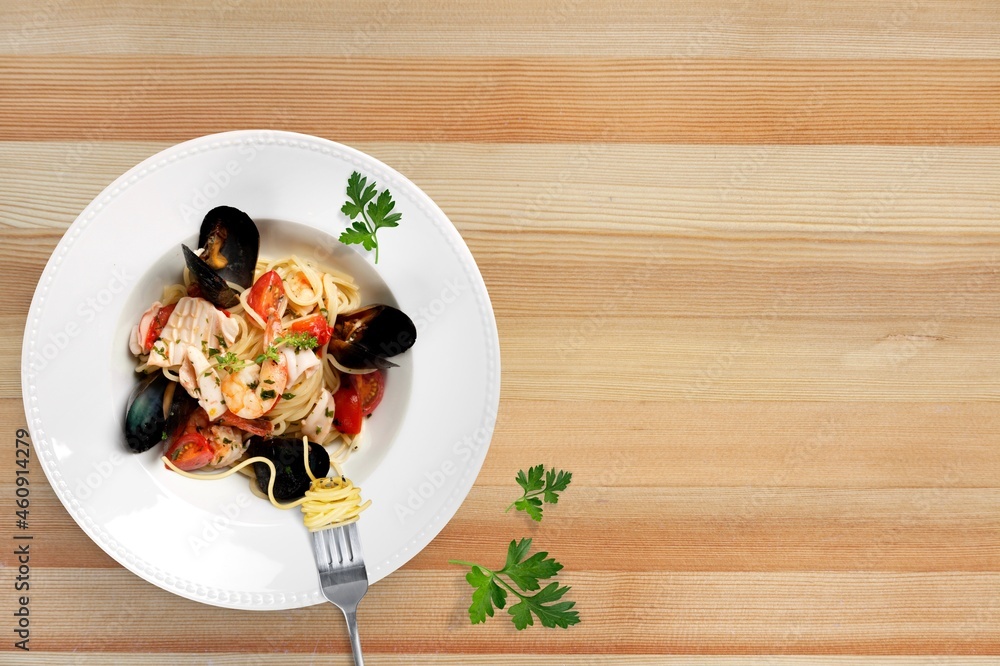 Mixed tasty seafood in plate on a gray stone background. Raw Shrimp, mussels and scallops