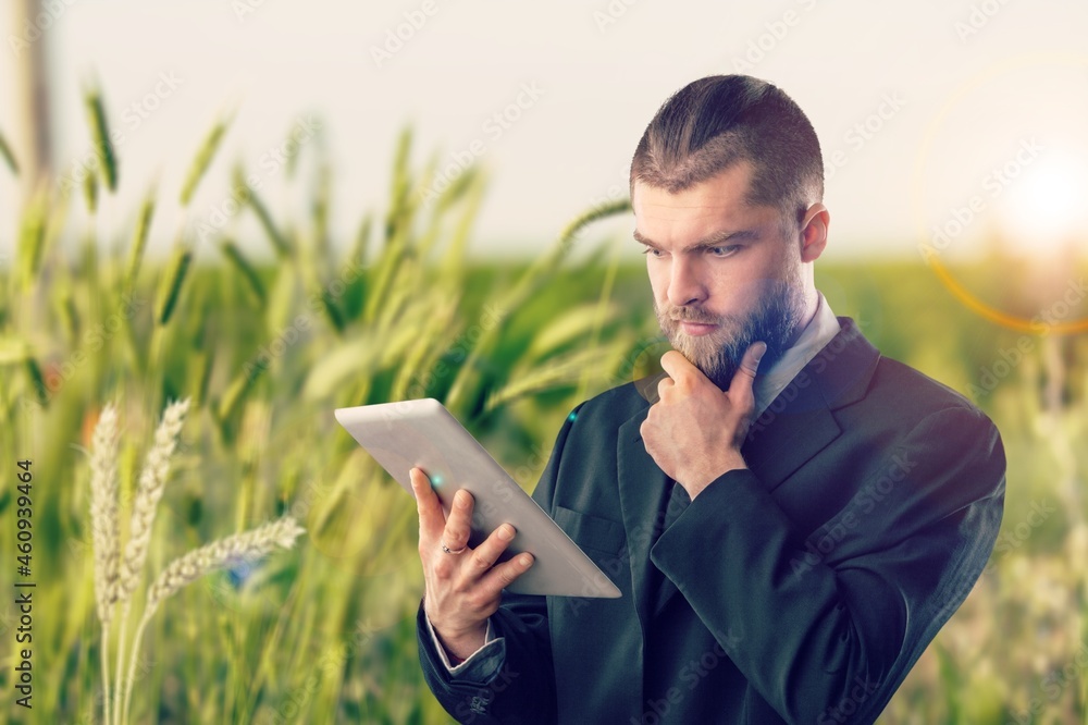 Young male farmer working with digital tablet on sugarcane plantation.