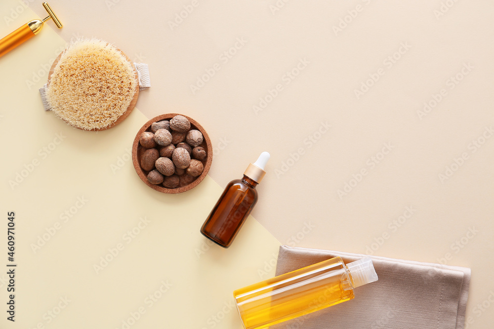 Bottle of nutmeg essential oil and massage tools on light background