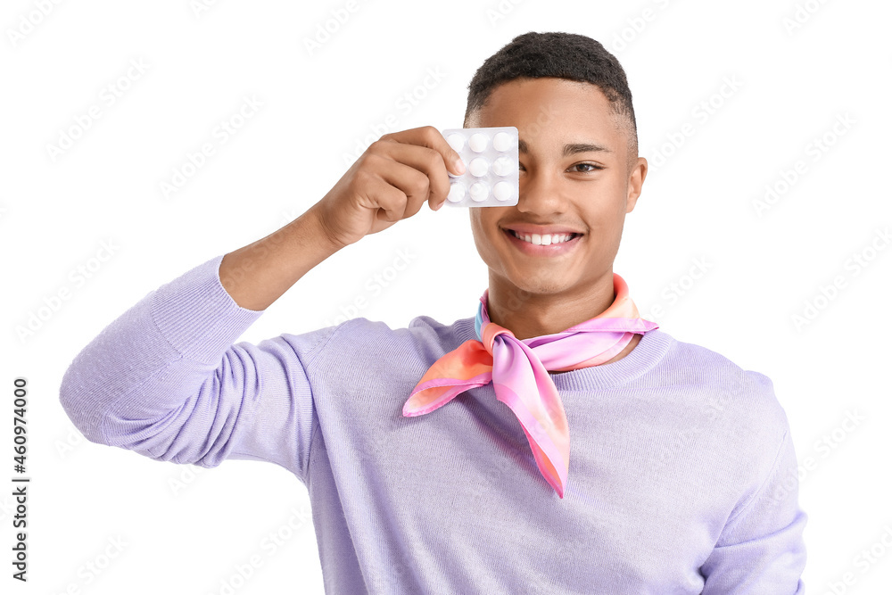 Happy African-American guy with blister of chewing gum on white background