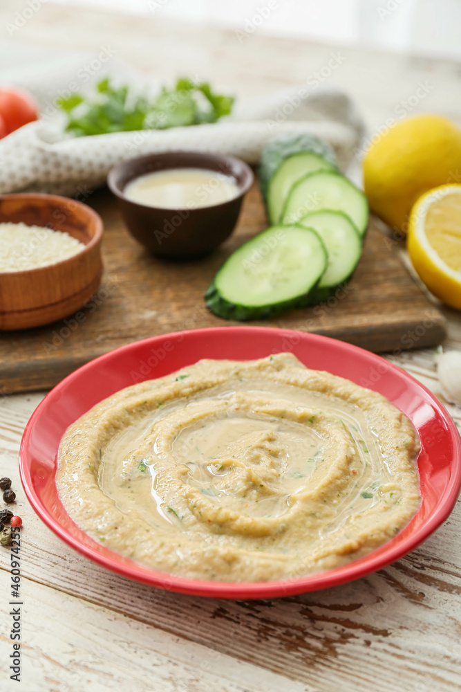 白色木质背景上的美味baba ghanoush碗，特写