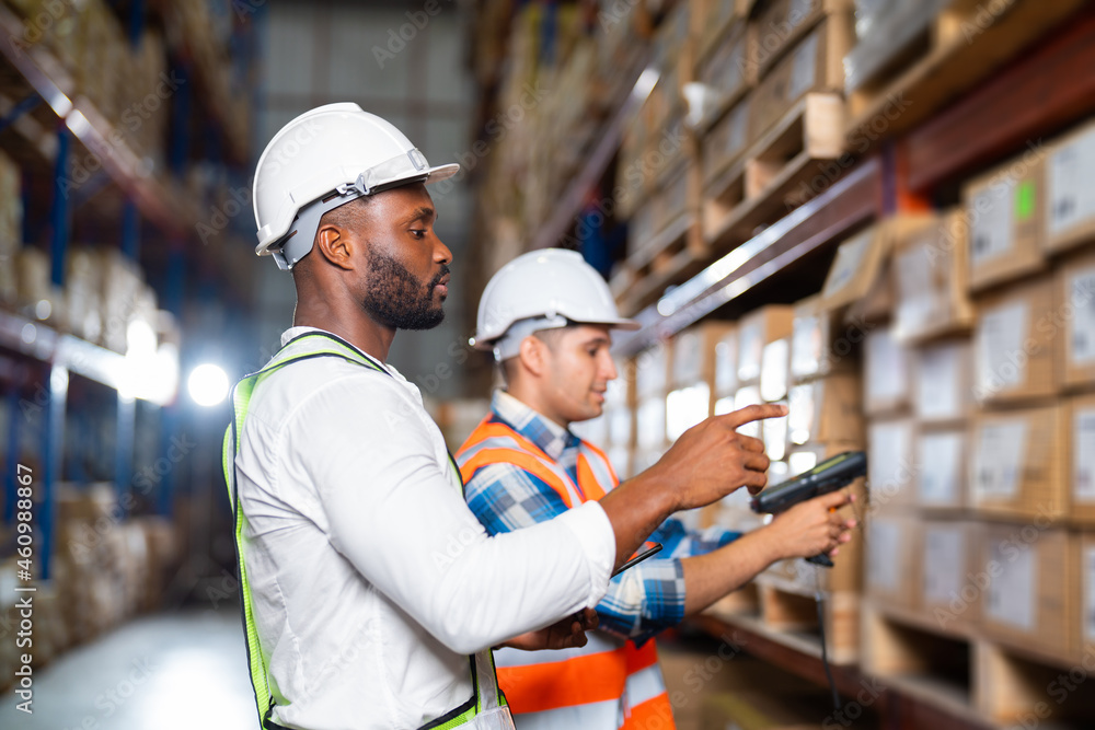 Warehouse workers checking inventory packages on the shelf in a large distribution center