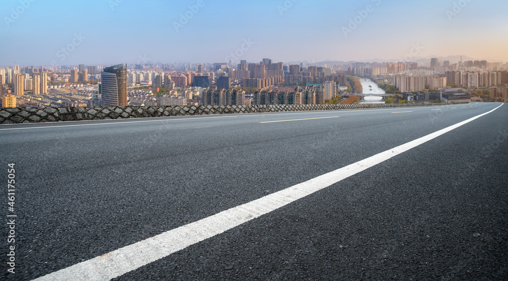 空旷的柏油路、城市天际线和建筑景观，中国。