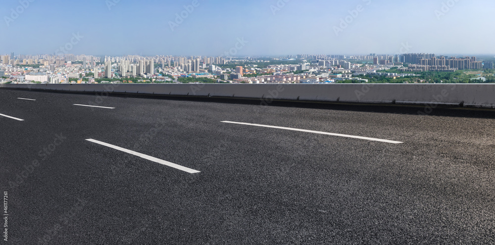 空旷的柏油路、城市天际线和建筑景观，中国。