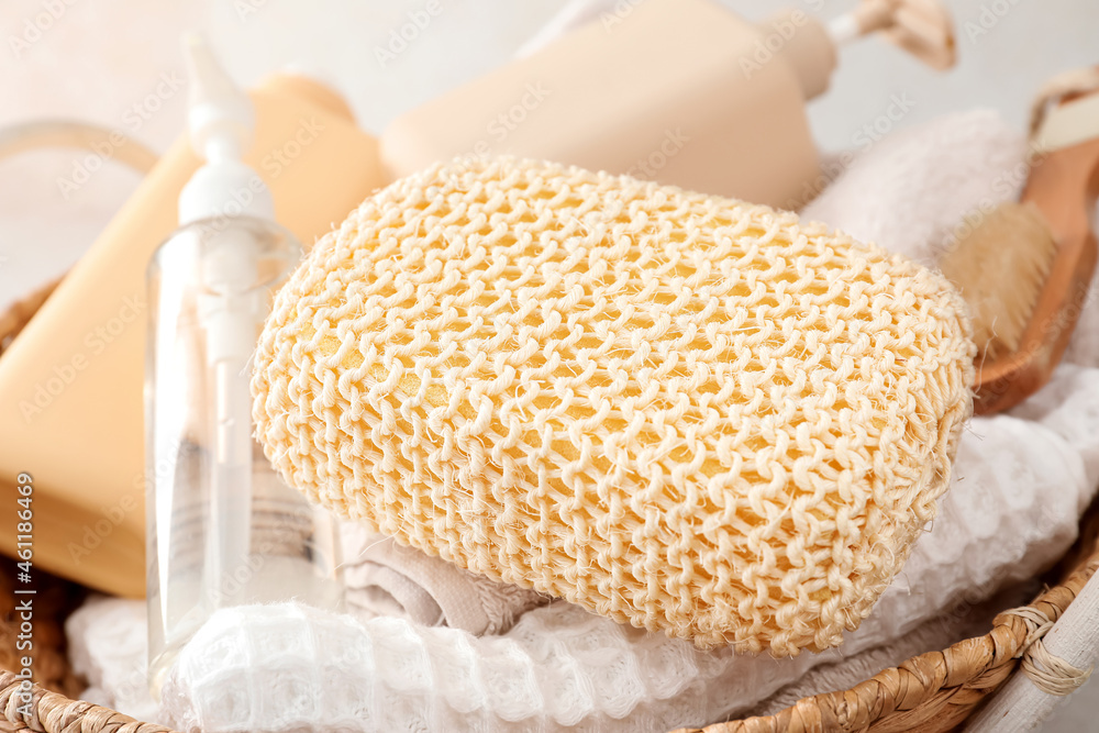 Loofah sponge with bath products in basket, closeup