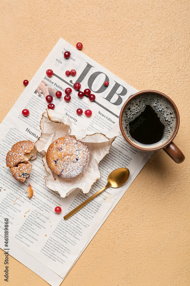 Tasty cranberry muffins, newspaper and cup of coffee on color background