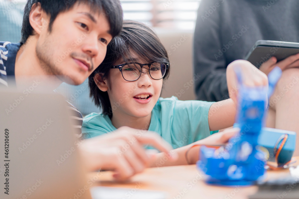 study robot automation at home concept,asian boy child with father 
 mom control robot arm on Digita