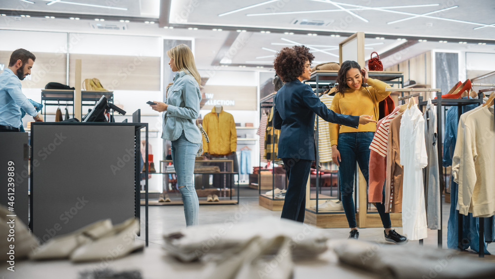 Customers Shopping in Modern Clothing Store, Retail Sales Associate Assists Client. Diverse People i