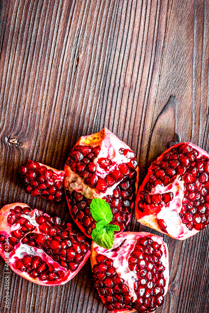 sliced pomegranate on wooden background top view