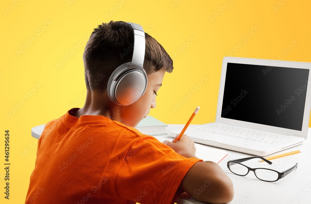 Back to school. Happy little pupil at the desk. Child doing homework