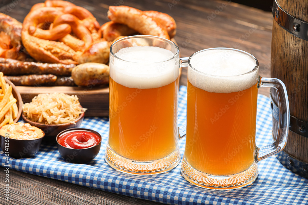 Mugs of cold beer and snacks on table. Oktoberfest celebration