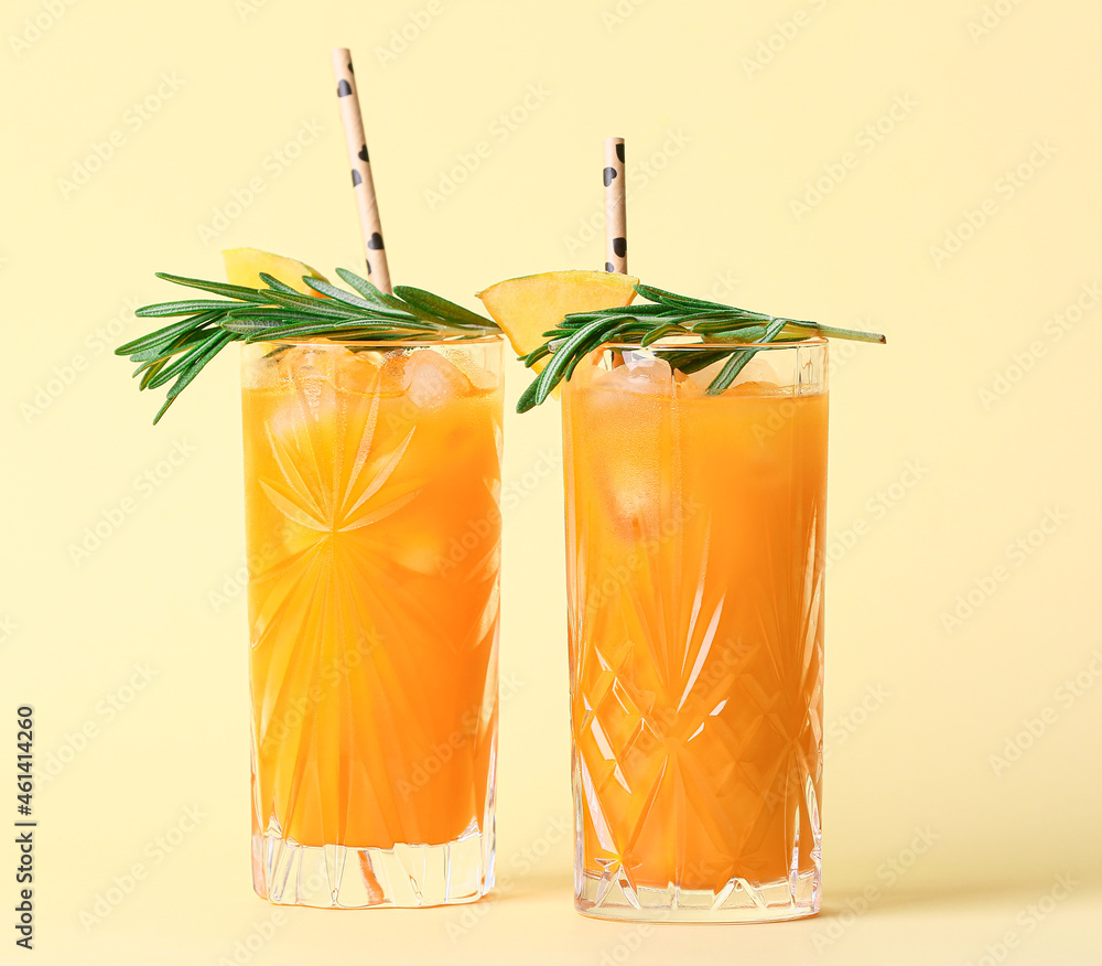 Glasses of cold melon cocktail garnished with rosemary on color background