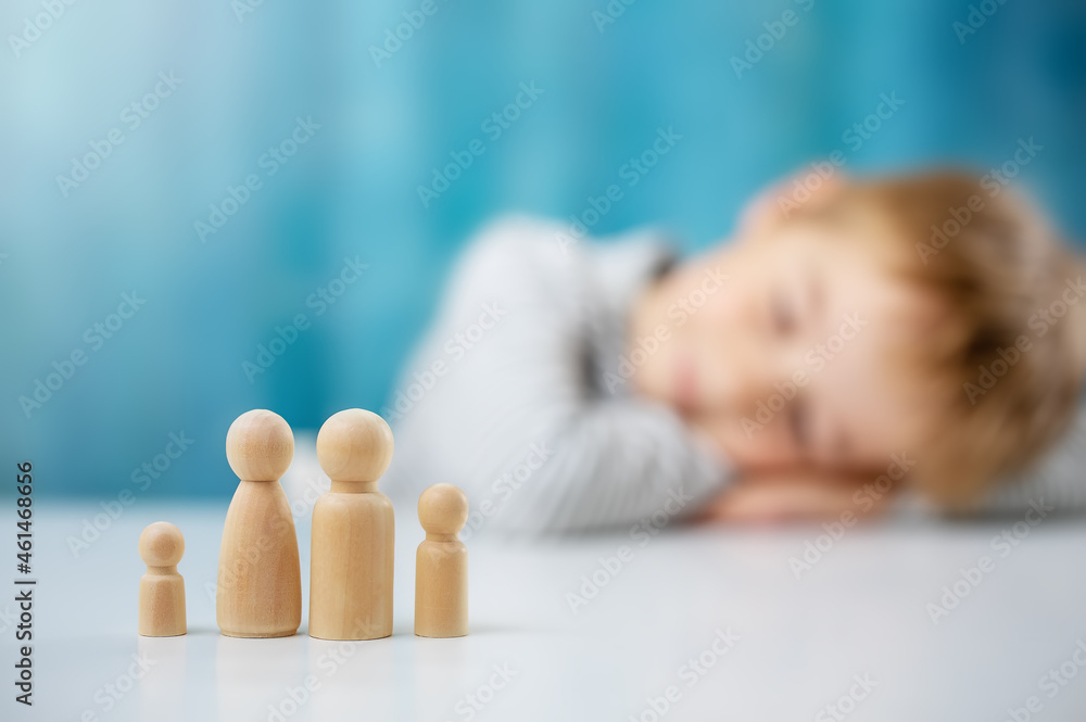 Child with wooden figures of the family on the blue background